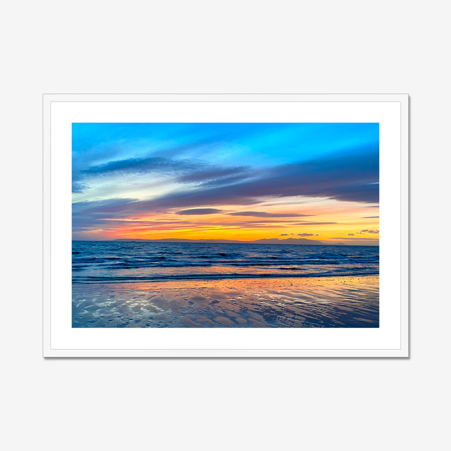Framed artwork of a sunset over water with a white frame.