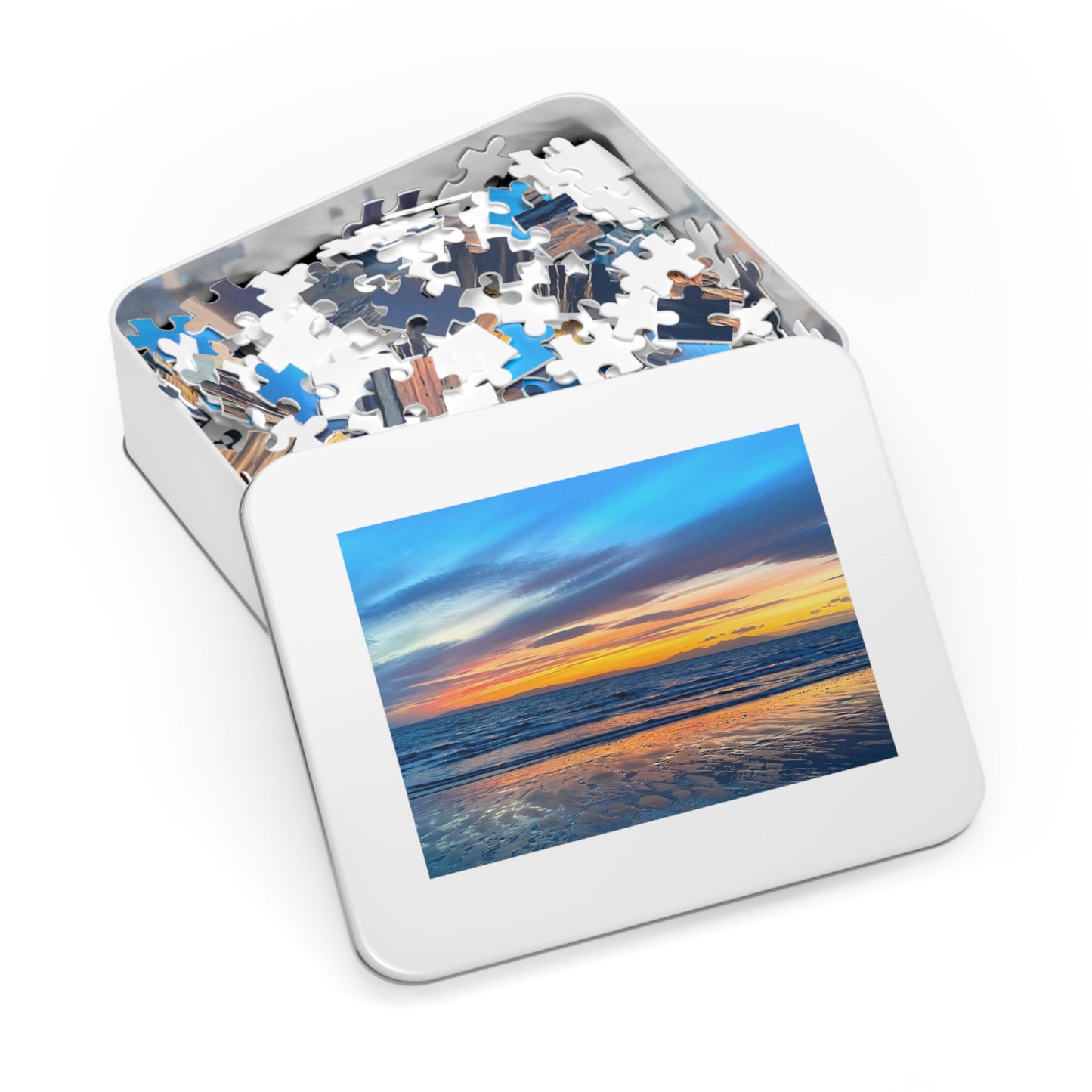 Jigsaw puzzle in a tin box with a scenic beach sunset design on the lid