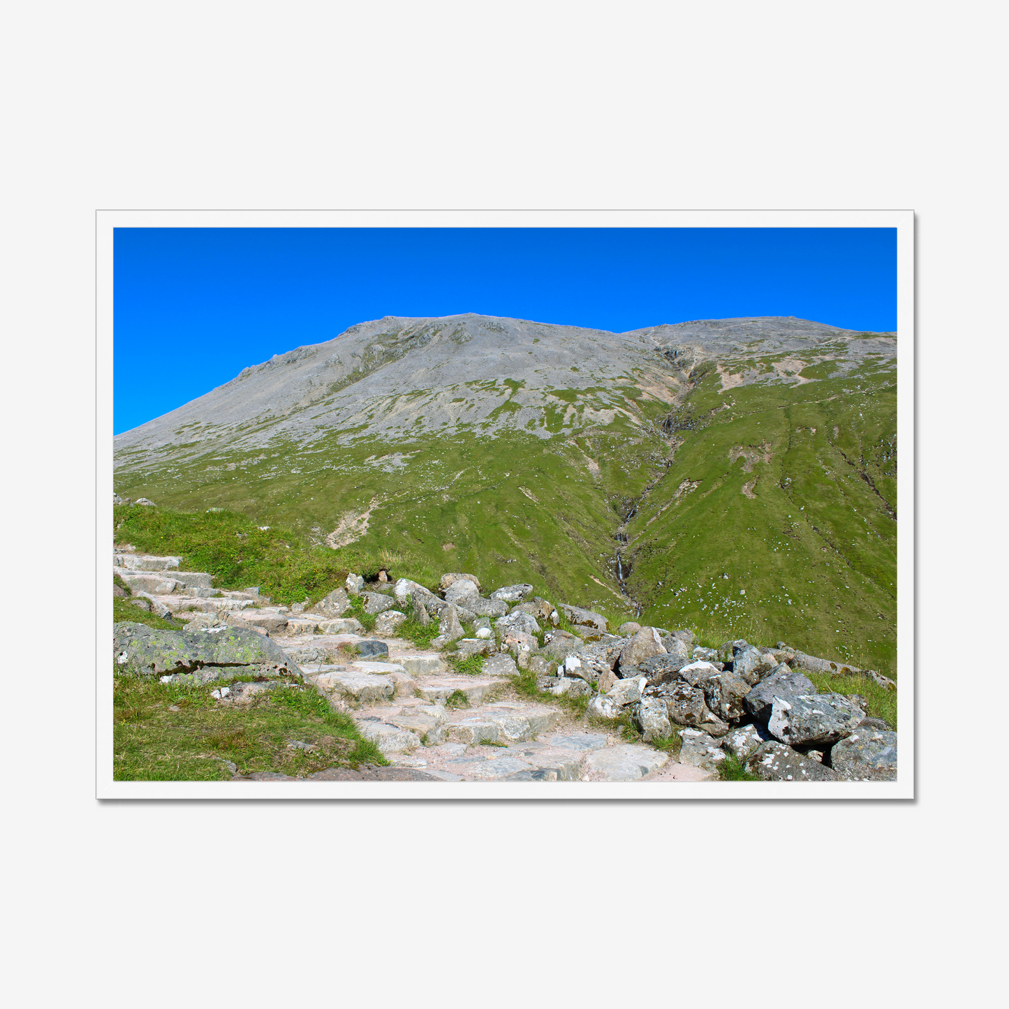 Framed photograph of a mountain landscape with a clear blue sky.