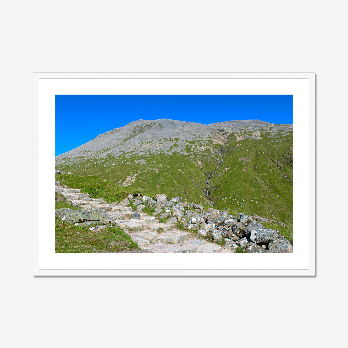 Framed photograph of a mountain landscape with a clear blue sky.