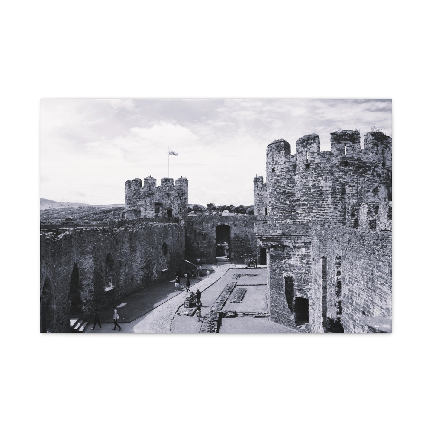Black and white photo of a castle courtyard with people walking around.