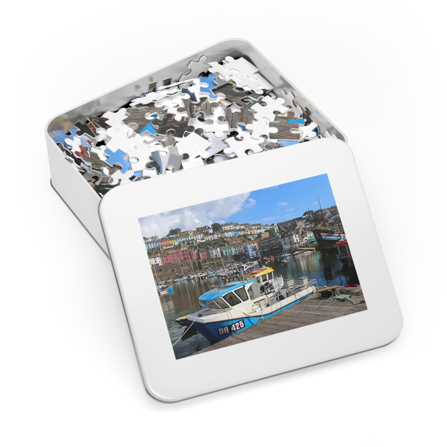 Jigsaw puzzle in a tin with a scenic picture of a harbor on the lid