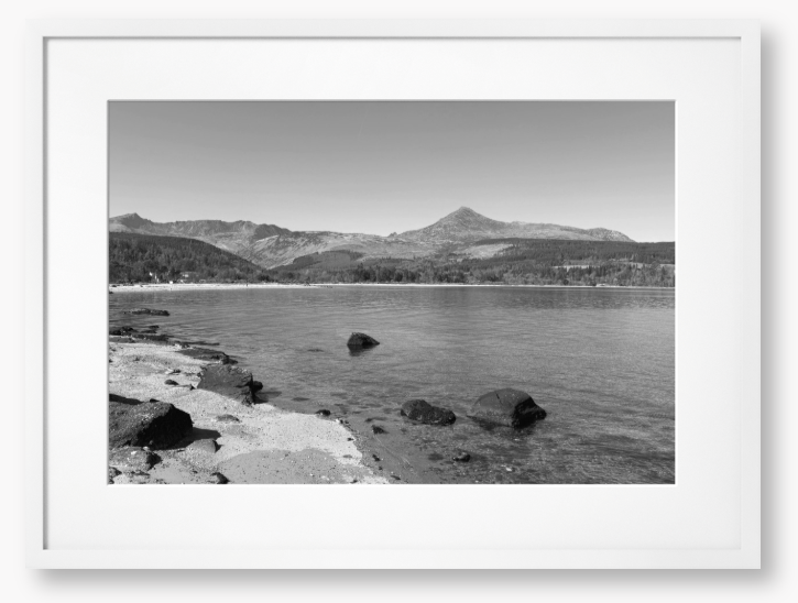 A black and white framed photo of Brodick Bay on the Isle of Arran, showing the beach and mountains in the background with a clear sky.
