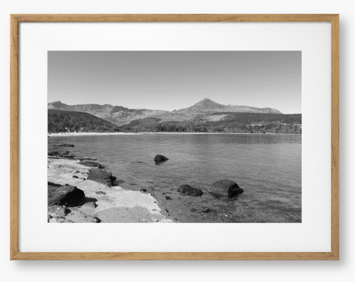 A black and white framed photo of Brodick Bay on the Isle of Arran, showing the beach and mountains in the background with a clear sky.