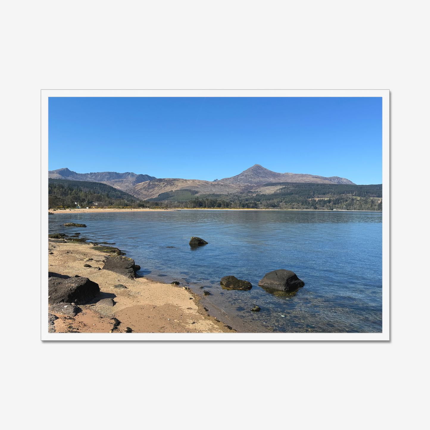 Framed photograph of a coastal scene with mountains in the background