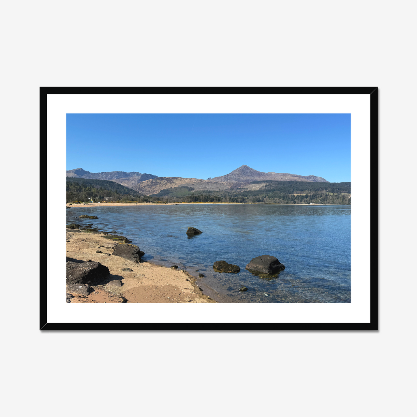Framed photograph of a coastal scene with mountains in the background