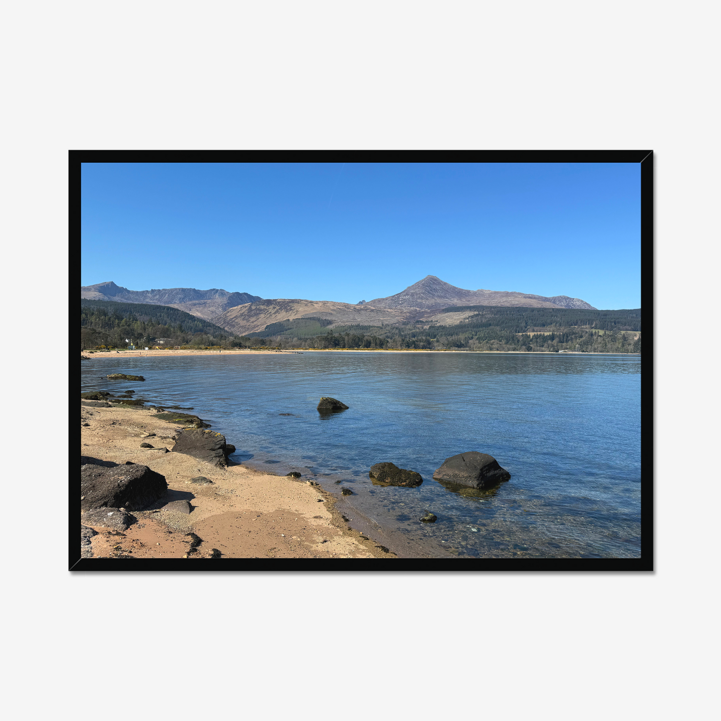 Framed photograph of a coastal scene with mountains in the background