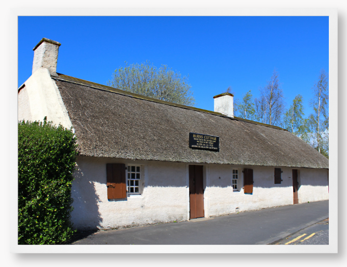 Framed Photo Of A Traditional thatched cottage with a blue sky and trees in the background
