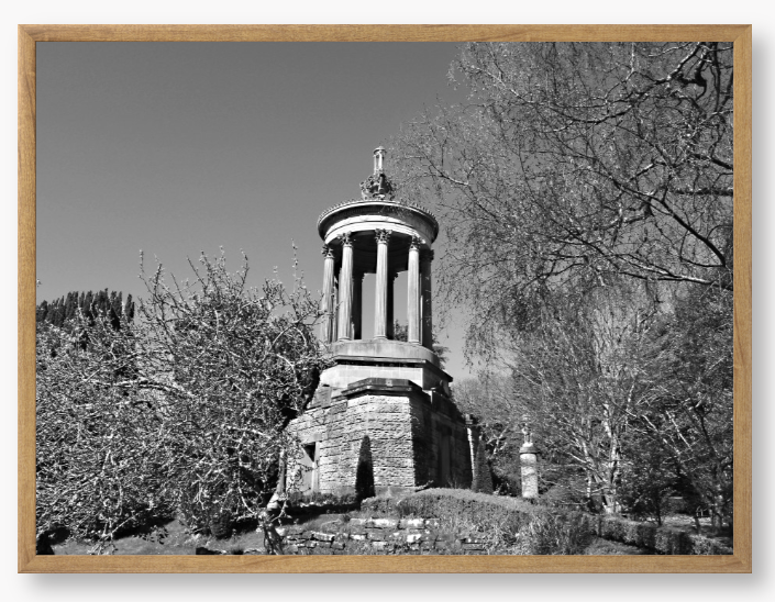 Black and White Framed Photo Of A Stone monument in a park with trees