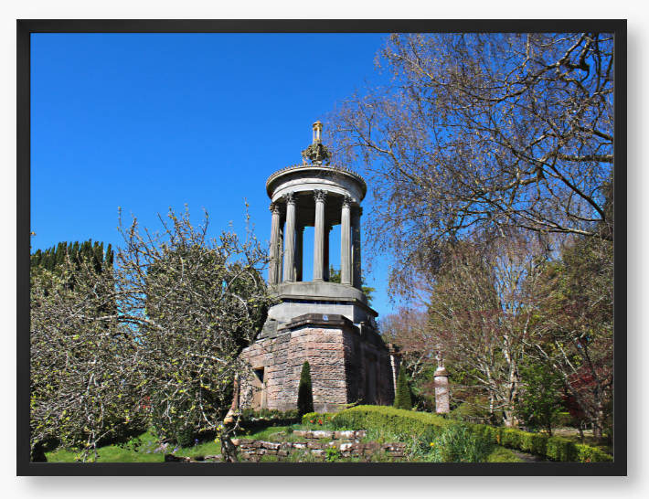 Framed Photo Of A Stone monument in a park with trees and blue sky
