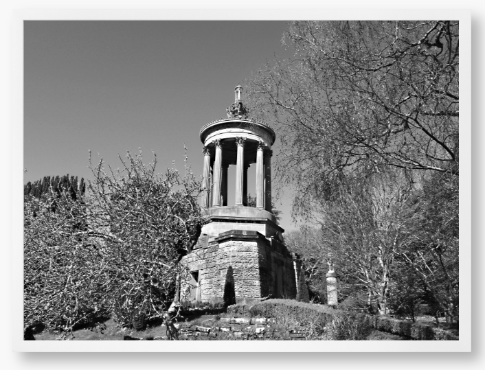 Black and White Framed Photo Of A Stone monument in a park with trees