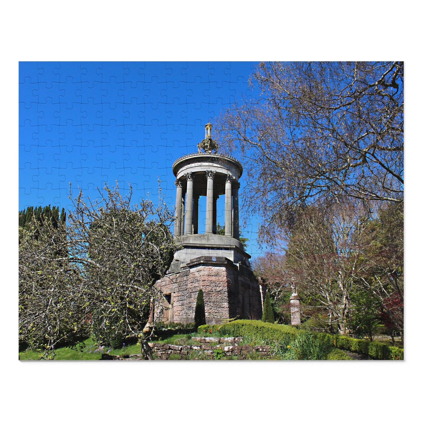 Stone monument in a garden with trees and blue sky