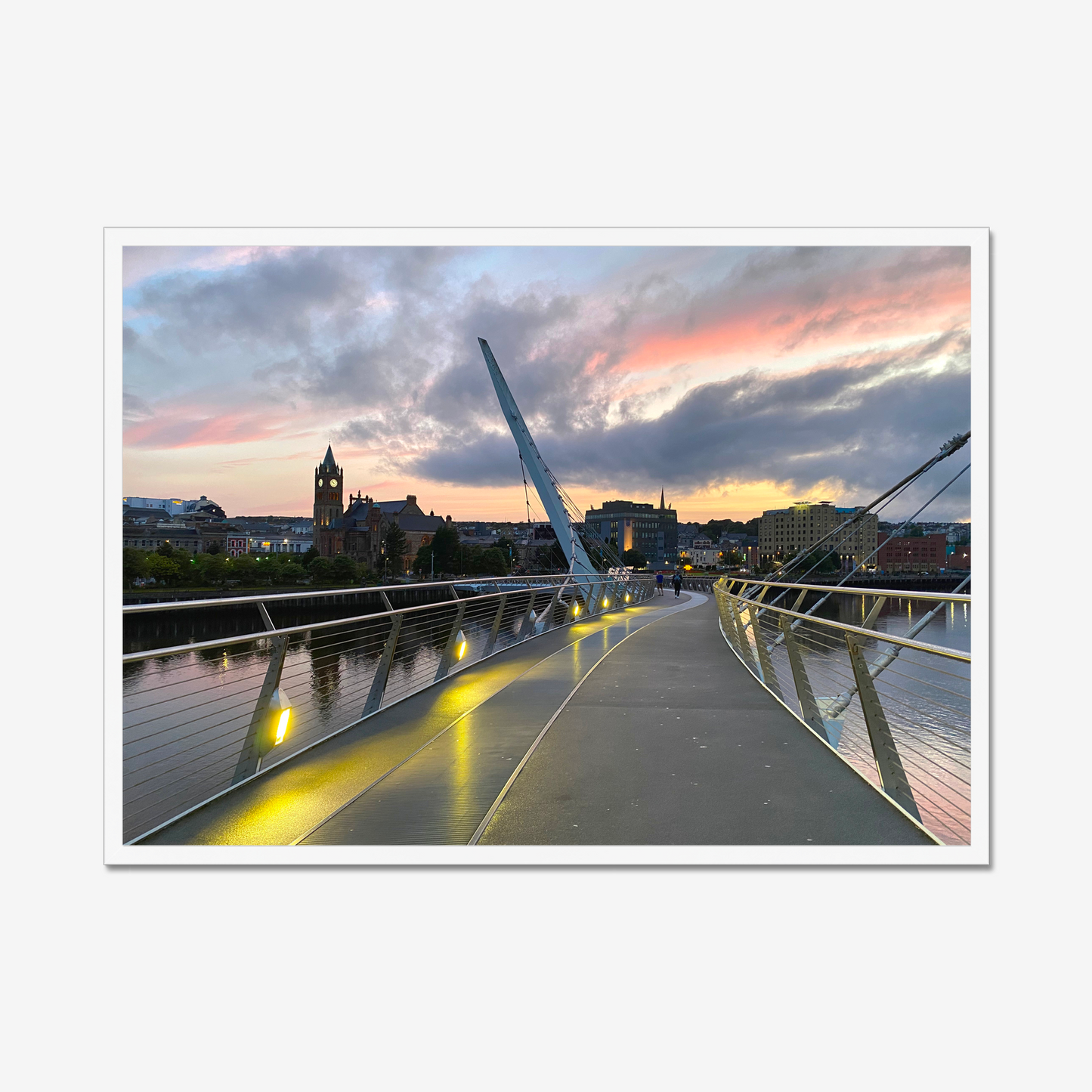 Modern bridge with a cityscape in the background during sunset.
