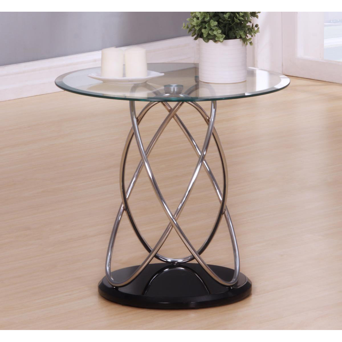 Glass side table with metal base on a wooden floor