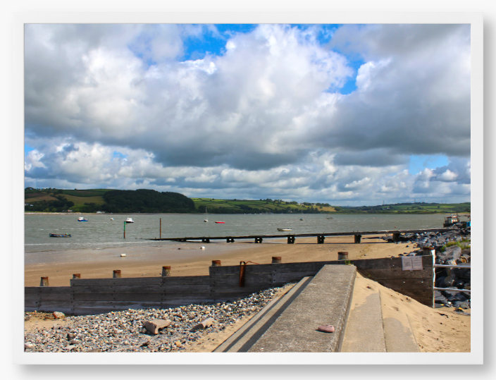 Framed Photo of a Beach scene with a large body of water, sky with clouds, and distant hills.
