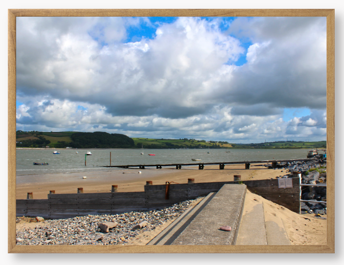 Framed Photo of a Beach scene with a large body of water, sky with clouds, and distant hills.