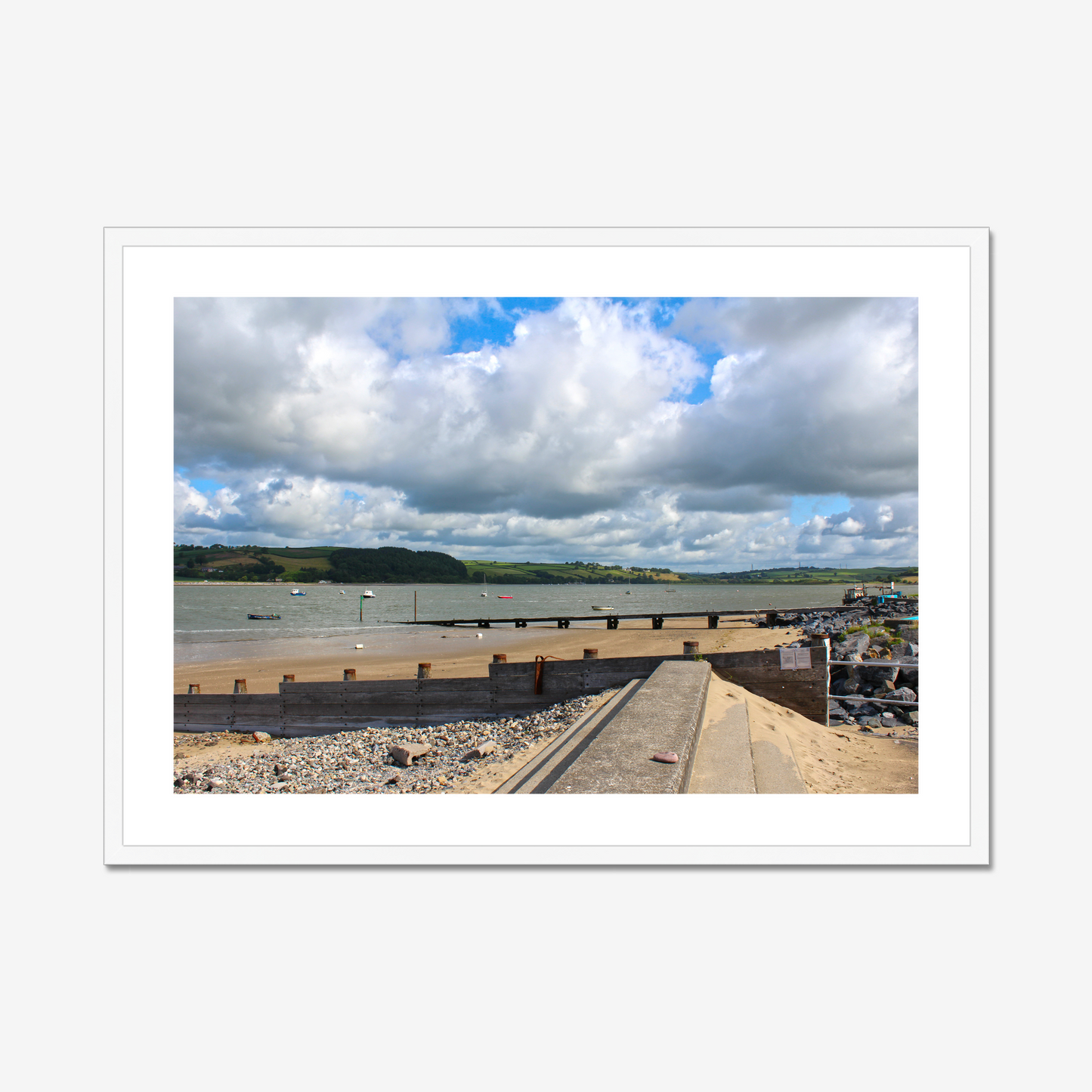 Framed photograph of a coastal scene with a dock and cloudy sky.