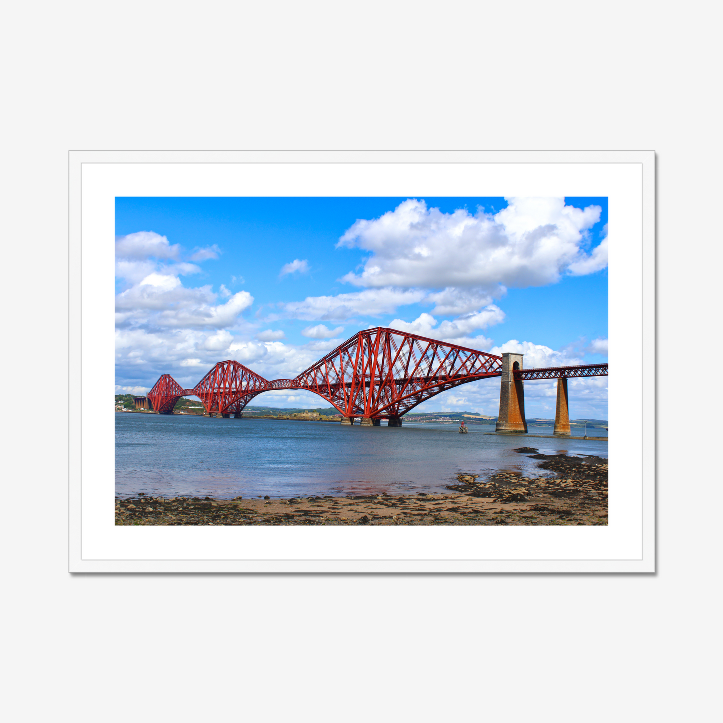 Framed photograph of a red bridge over water with a blue sky.