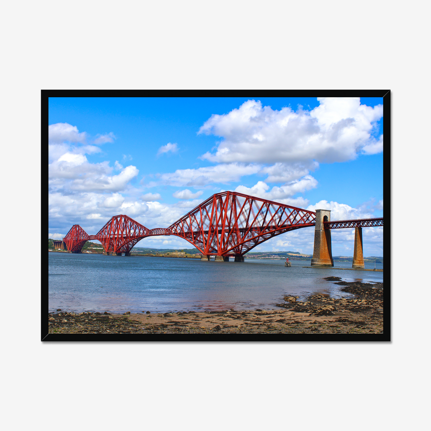 Red bridge over water with a blue sky and clouds, framed in black.