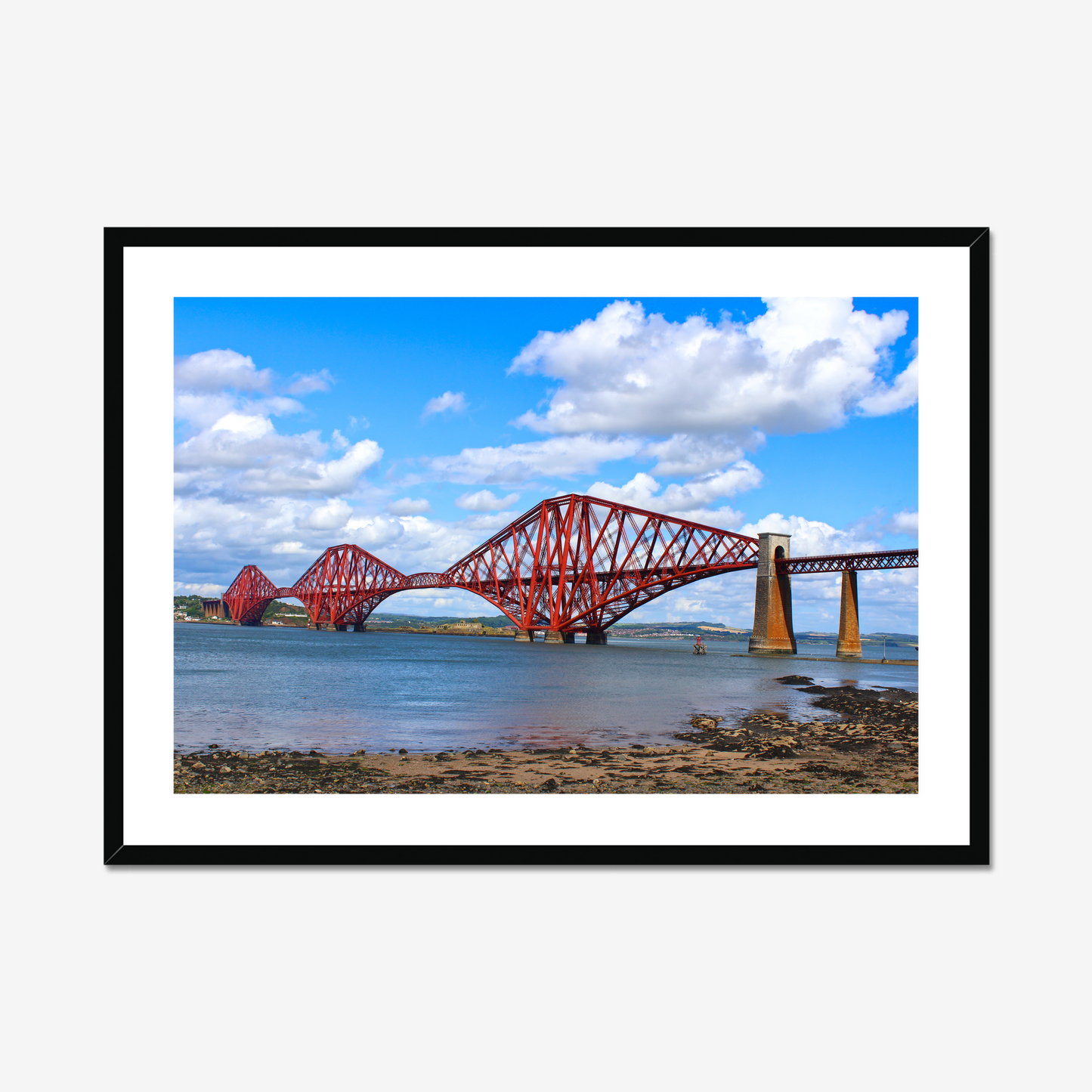 Framed photograph of a red bridge over water with a blue sky.