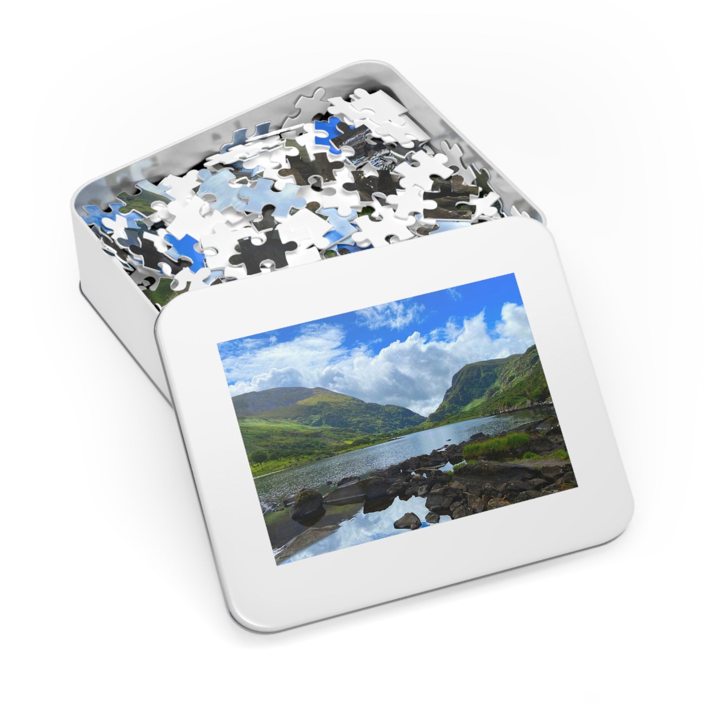 Jigsaw puzzle in a tin with a scenic view of mountains and lake on the cover