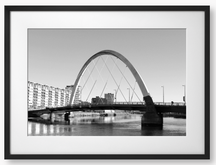 Black and White framed photo of the Glasgow Clyde Arc Bridge over the River Clyde, with a clear sky in the background.