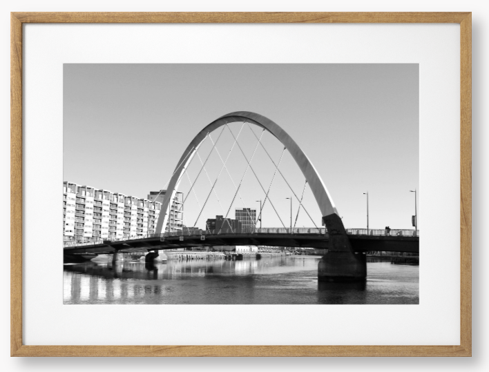 Black and White framed photo of the Glasgow Clyde Arc Bridge over the River Clyde, with a clear sky in the background.