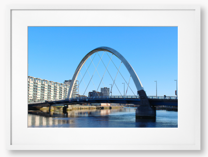 A framed photo of the Glasgow Clyde Arc Bridge over the River Clyde, with a clear blue sky in the background.