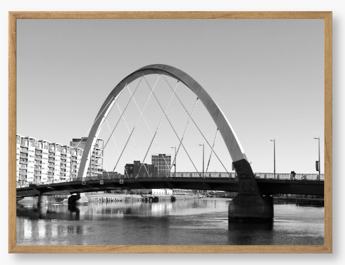 Black and White framed photo of the Glasgow Clyde Arc Bridge over the River Clyde, with a clear sky in the background.