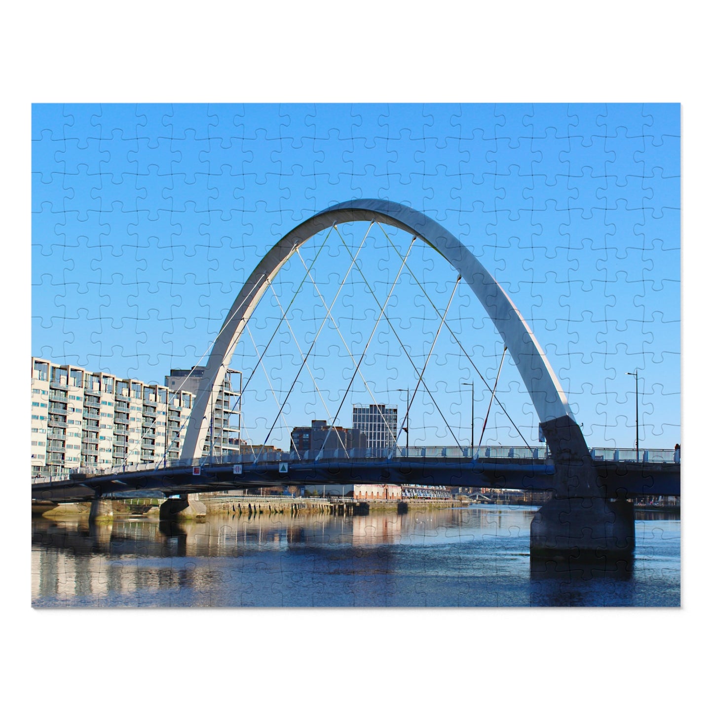 Arch bridge over a body of water with buildings in the background