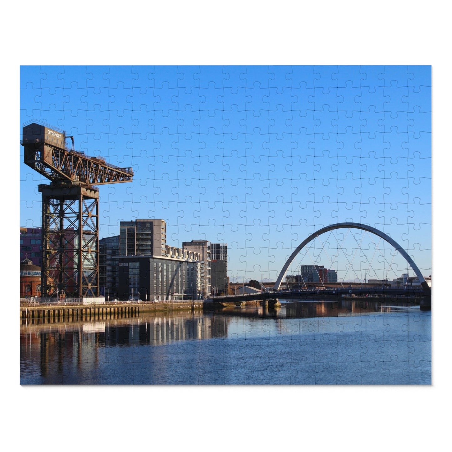 Cityscape with a crane and arch bridge over water on a clear day