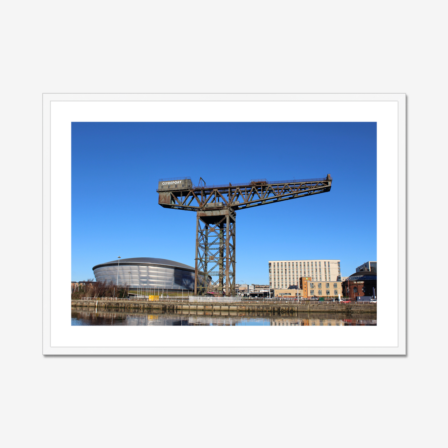 Framed photograph of a large crane with a modern building in the background
