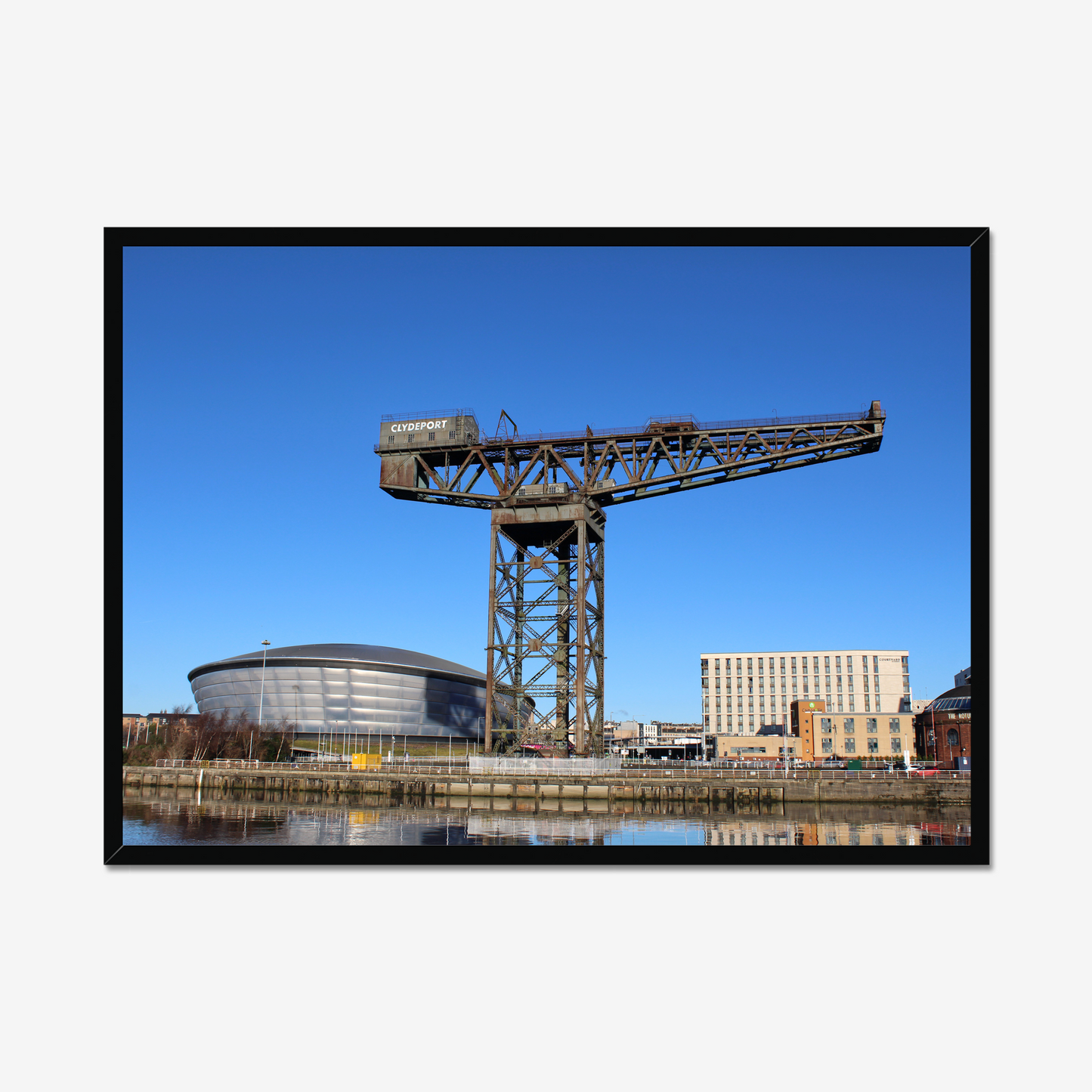 Framed photograph of a large crane with a modern building in the background