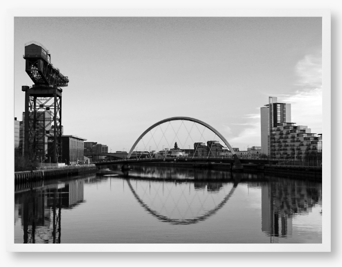 Black and White framed photograph of Glasgow's River Clyde with reflections, including a prominent crane and modern cityscape in the background.