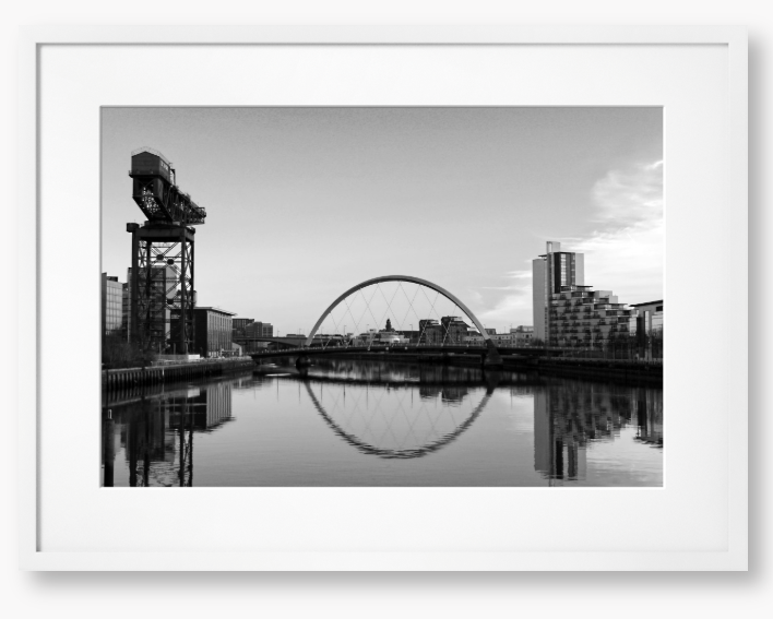 Black and White framed photograph of Glasgow's River Clyde with reflections, including a prominent crane and modern cityscape in the background.