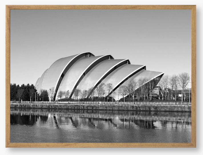 Black and white framed photo of a modern architectural structure reflected in water