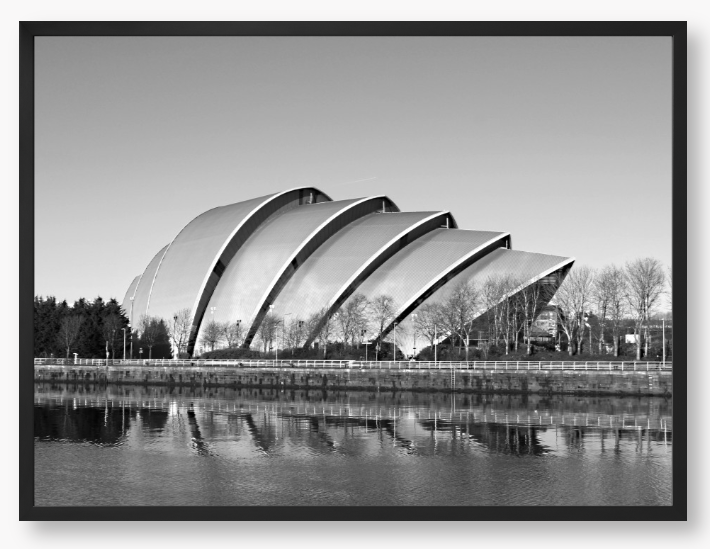Black and white framed photo of a modern architectural structure reflected in water