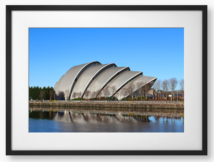 Framed Photo of a Modern architectural building reflected in water with a clear blue sky