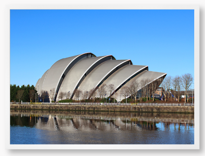Framed Photo of a Modern architectural building reflected in water with a clear blue sky