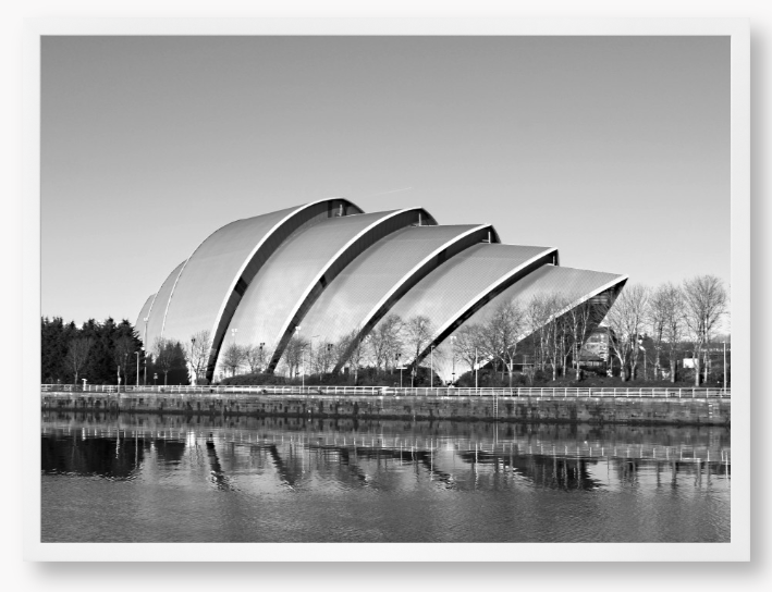 Black and white framed photo of a modern architectural structure reflected in water