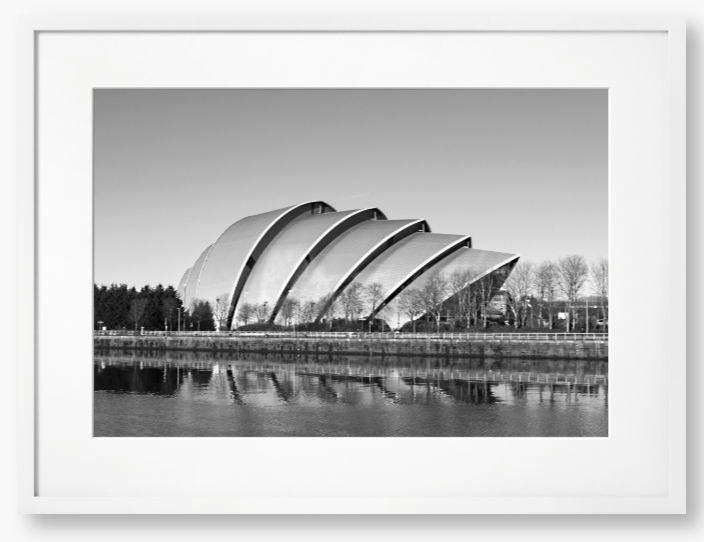 Black and white framed photo of a modern architectural structure reflected in water