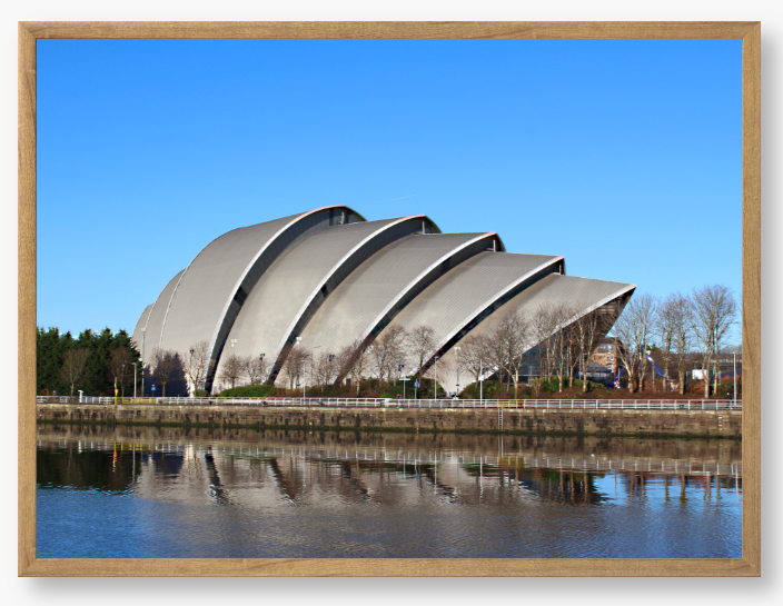 Framed Photo of a Modern architectural building reflected in water with a clear blue sky