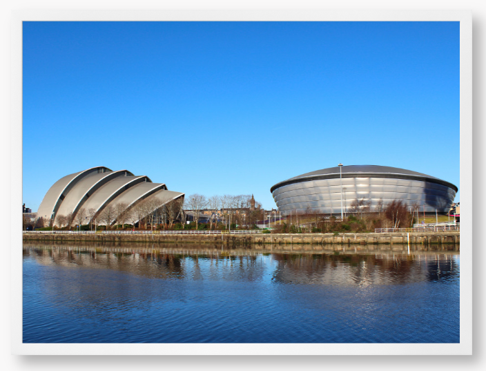 Framed Photo of Modern architectural buildings reflected in water with a clear blue sky