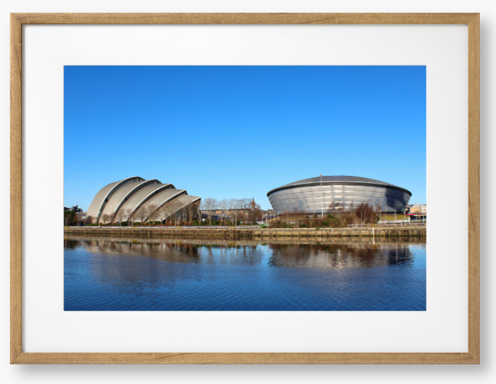 Framed Photo of Modern architectural buildings reflected in water with a clear blue sky