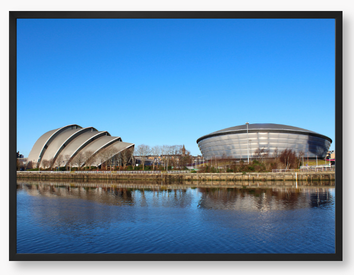 Framed Photo of Modern architectural buildings reflected in water with a clear blue sky