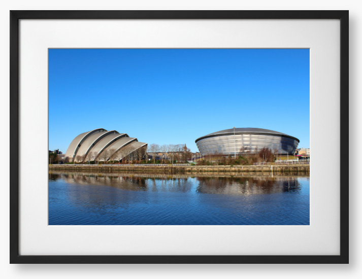 Framed Photo of Modern architectural buildings reflected in water with a clear blue sky