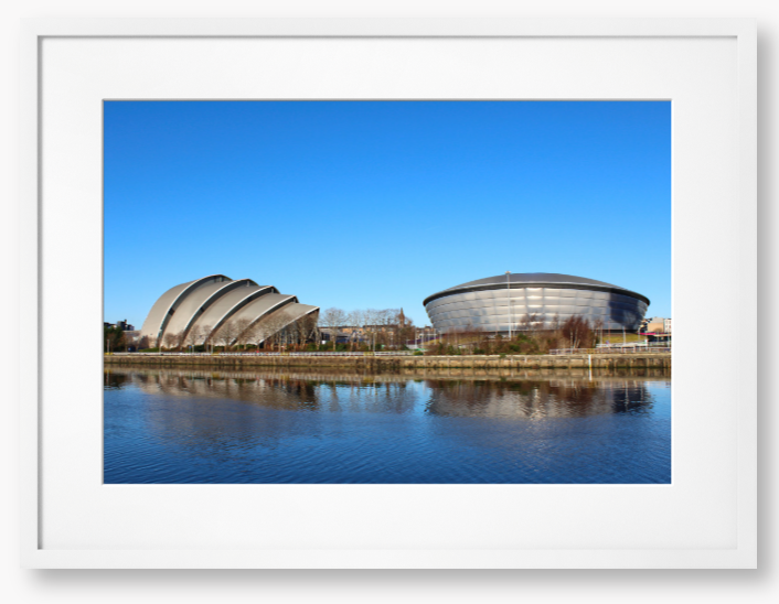 Framed Photo of Modern architectural buildings reflected in water with a clear blue sky