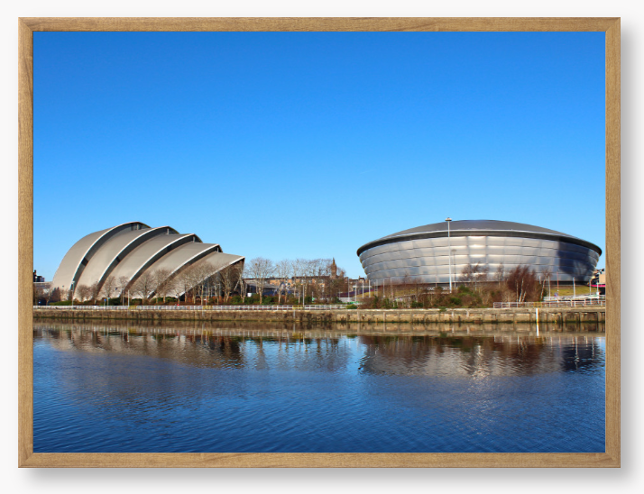 Framed Photo of Modern architectural buildings reflected in water with a clear blue sky
