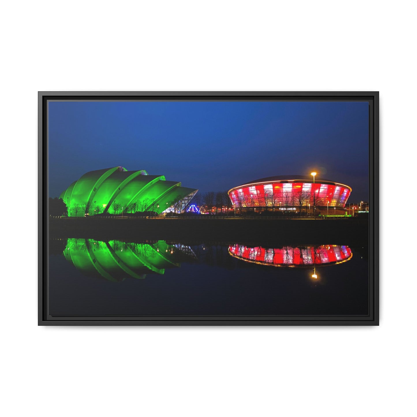 Two illuminated buildings, one green and one red and white, reflected in water at night.