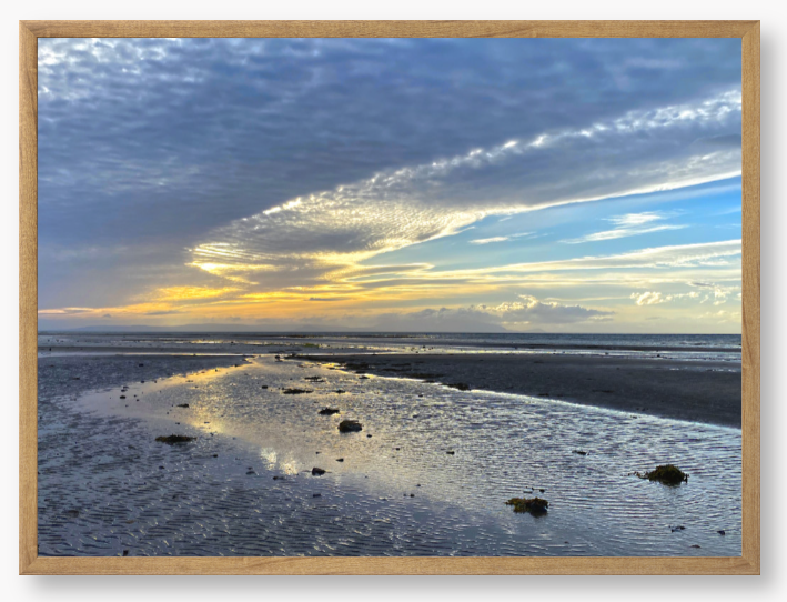 Framed Photo Of A Sunset over a beach with clouds and water reflections